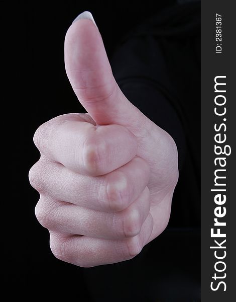 Thumbs up against black background