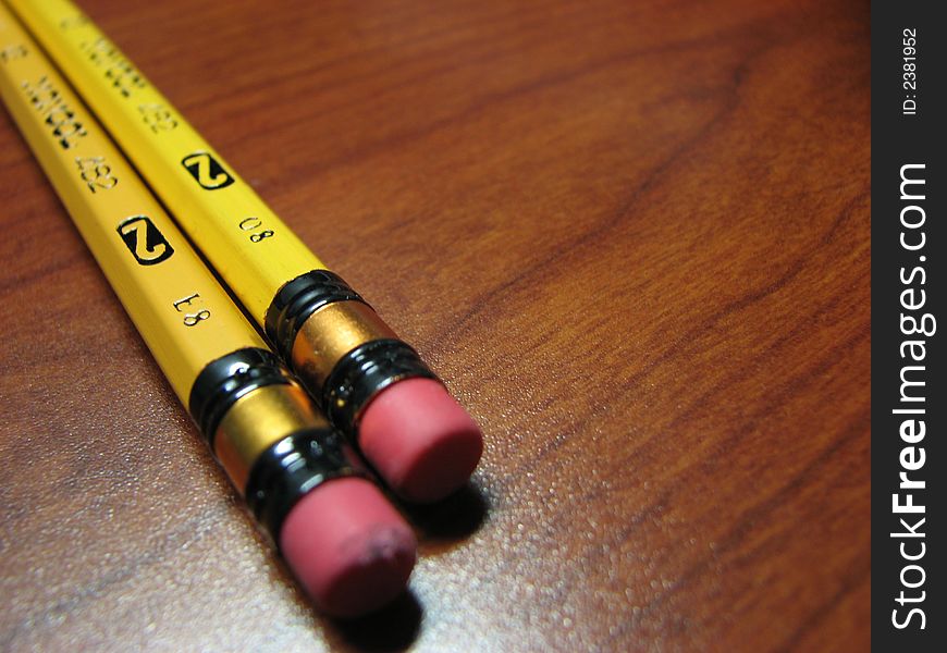Pencils on wooden desktop with emphasis on the eraser tip