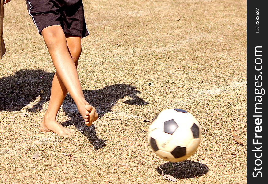 A boy is kicking the ball.