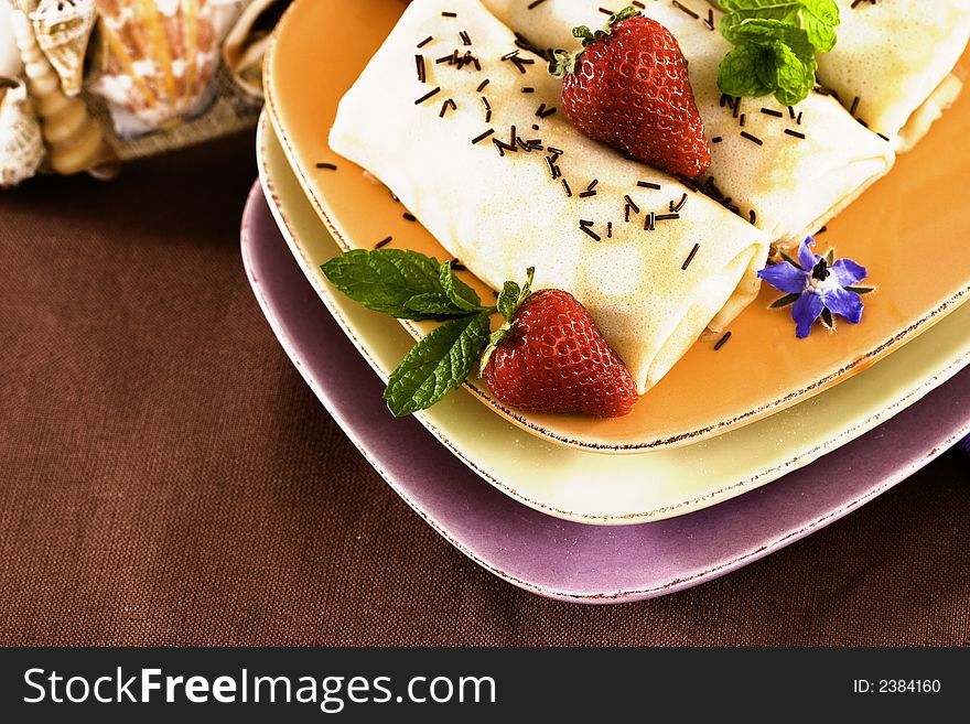 Crepes On Golden Plate With Mint, Chocolate Sprinkles, Strawberries And Edible Borage Flowers. Crepes On Golden Plate With Mint, Chocolate Sprinkles, Strawberries And Edible Borage Flowers