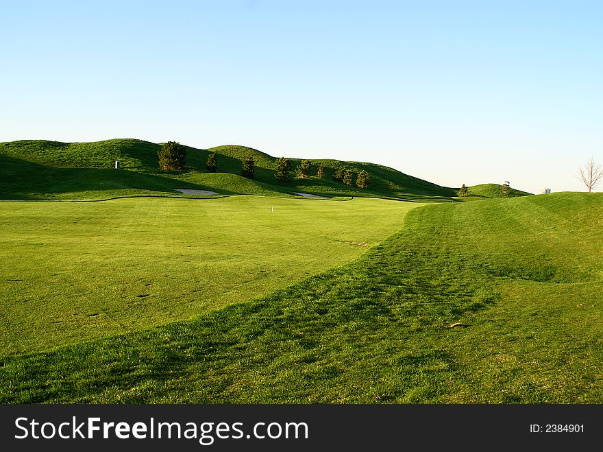 Photo of green golf course with beutiful clouds background. Photo of green golf course with beutiful clouds background