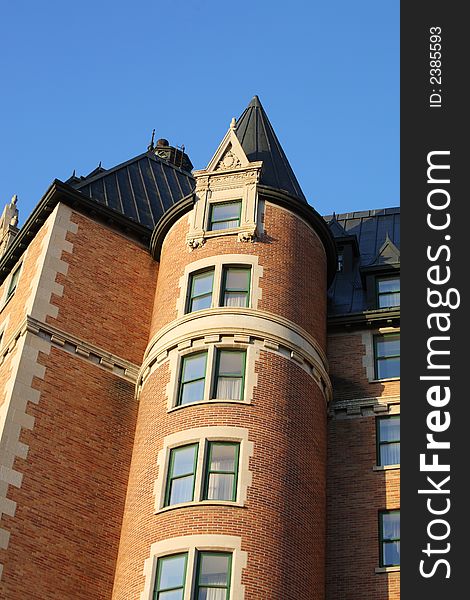 A stately castle turret marks the corner of an old high-class hotel.