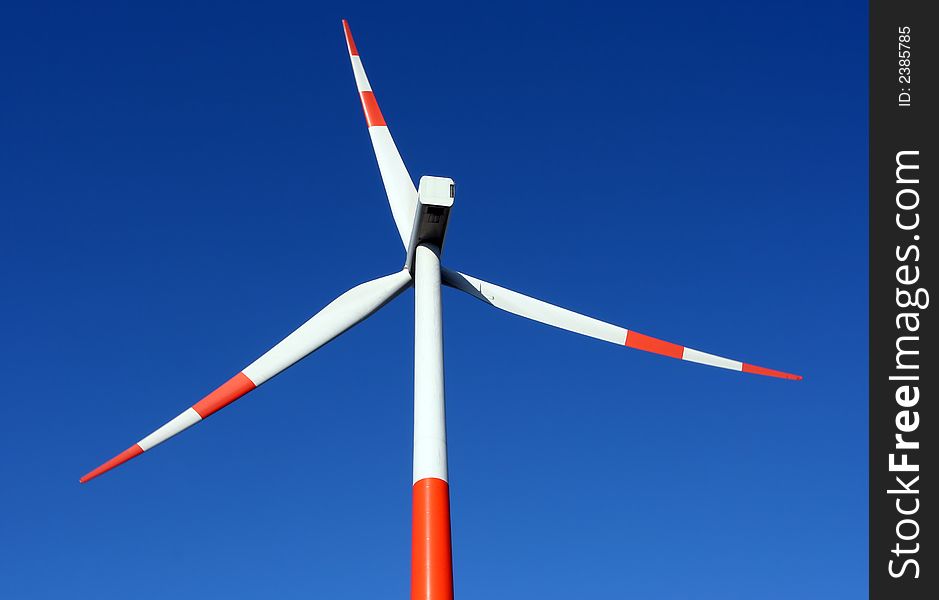 A red/ white windmill against a clear blue sky. A red/ white windmill against a clear blue sky