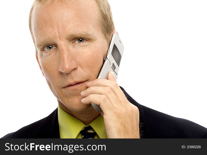 A businessman in a suit uses a cellular phone. A businessman in a suit uses a cellular phone