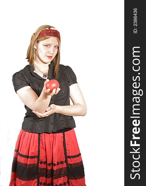 A pretty young woman in red and black offers an apple. A pretty young woman in red and black offers an apple
