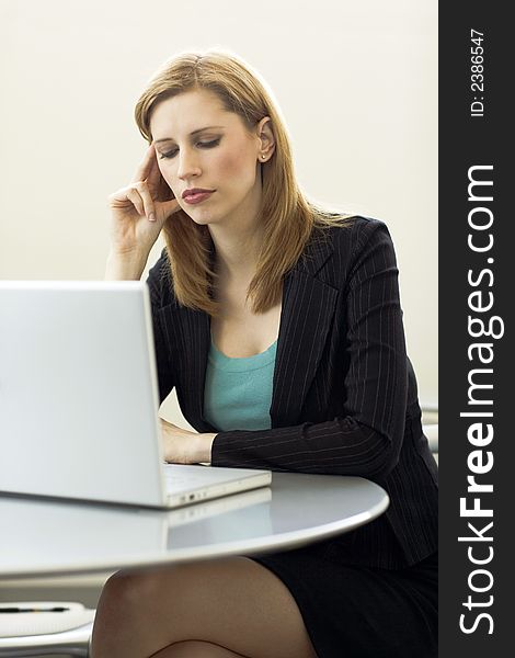 Businesswoman works with her laptop at a desk. Businesswoman works with her laptop at a desk