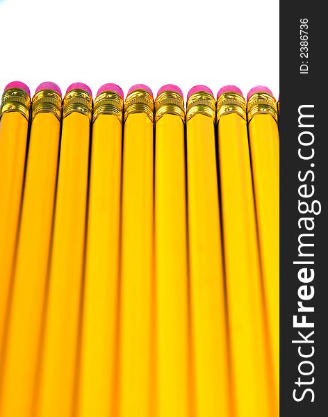 A row of yellow pencils with eraser, isolated over white
