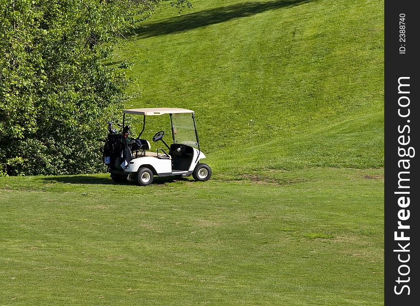 Empty white golf cart waiting on the green