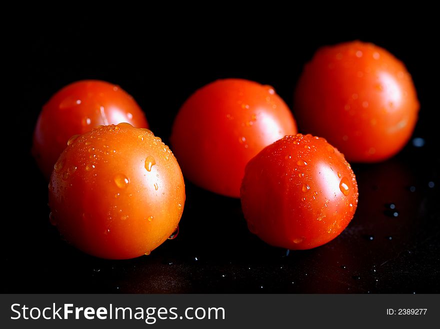 Fresh cherry tomato with water drops on black. Fresh cherry tomato with water drops on black