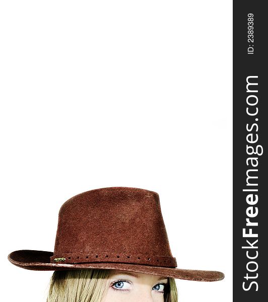 A thinking young beautiful woman with blue eyes is wearing a cowboy hat - stetson with space for text. A thinking young beautiful woman with blue eyes is wearing a cowboy hat - stetson with space for text