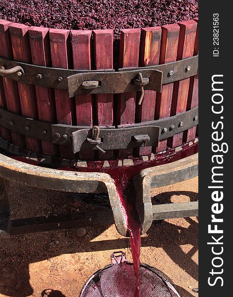 Manual wine press with red grape pomace pulp left over during the juice extraction process. Manual wine press with red grape pomace pulp left over during the juice extraction process