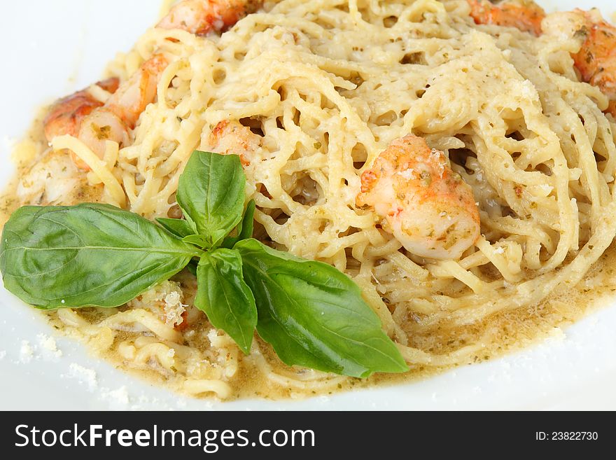 Noodles tagliolini with pesto and shrimps on a white background. Noodles tagliolini with pesto and shrimps on a white background.