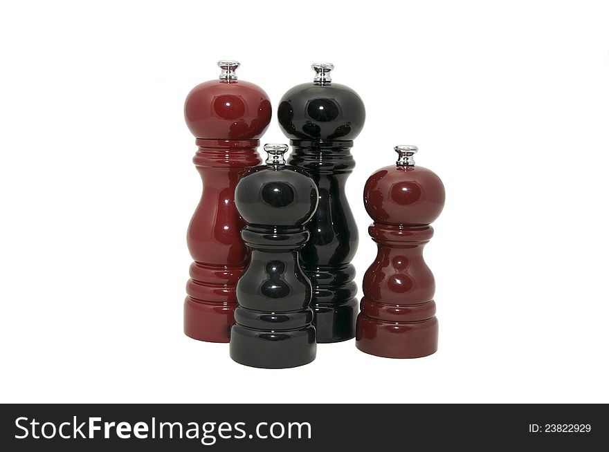 Four wooden pepper Mills on a white background