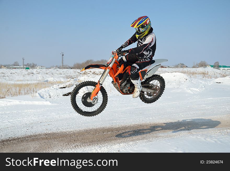 Motocross driver flies over hill out of snow