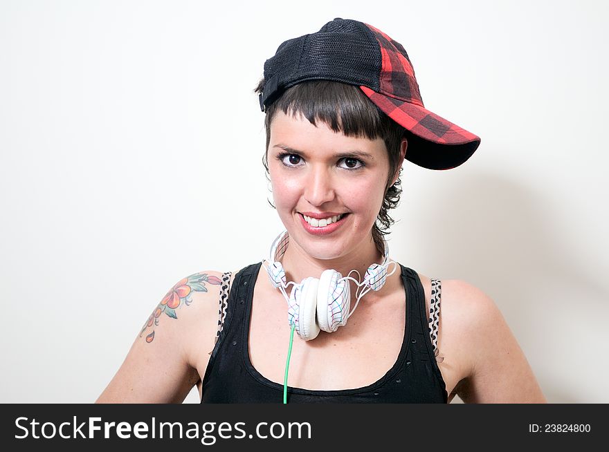 Portrait of cute young woman with headphones and cap