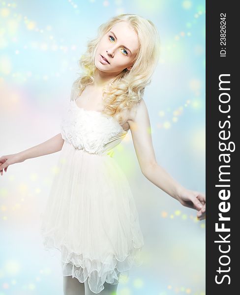 Beauty - attractive gentle blonde girl in white dress over blue blurred background. Beauty - attractive gentle blonde girl in white dress over blue blurred background