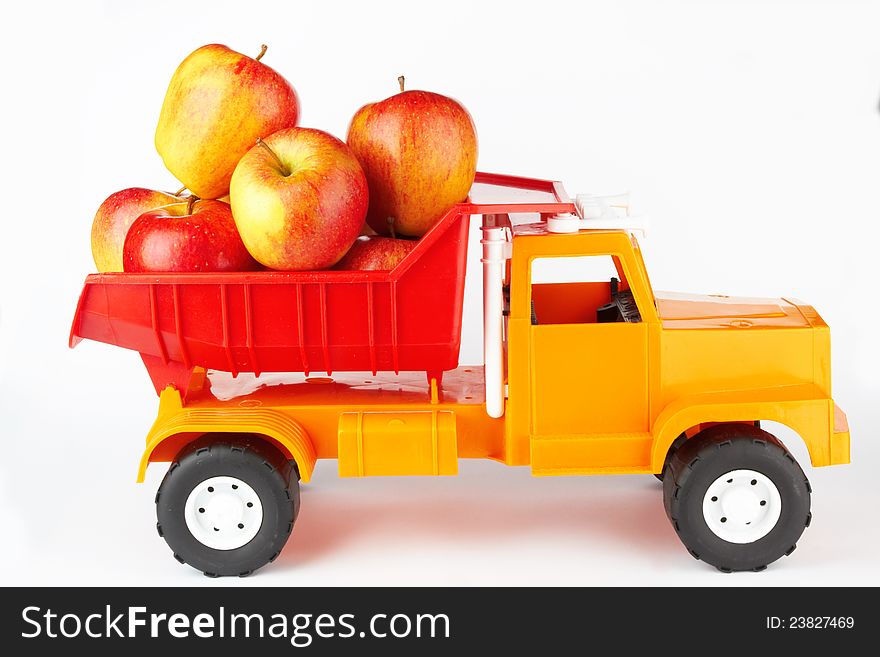 Toy lorry with apple on white