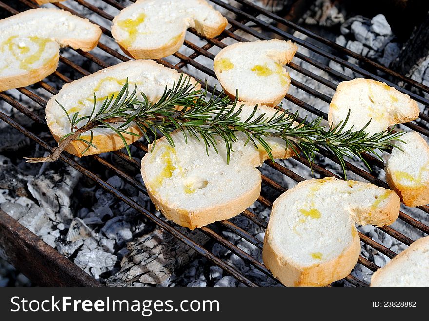 Slices of bread and rosemary on a barbecue