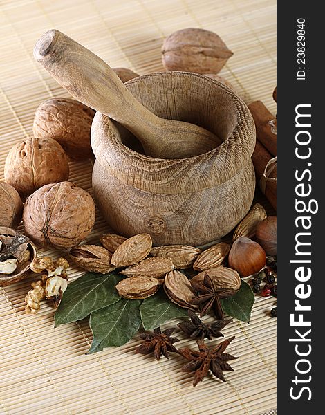 Wooden mortar and pestle with spices and nuts