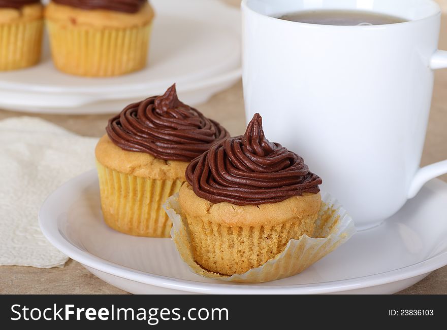 Cup cakes with chocolate icing and a cup of coffee. Cup cakes with chocolate icing and a cup of coffee