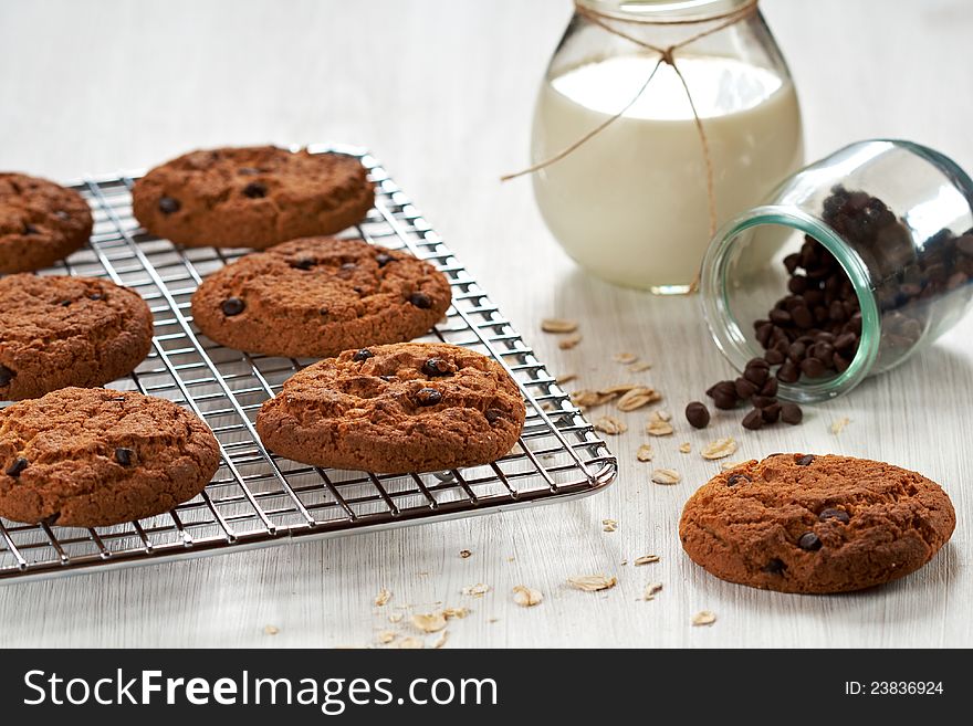 Chocolate chip oatmeal cookies on a cooling rack with ingredients. Chocolate chip oatmeal cookies on a cooling rack with ingredients