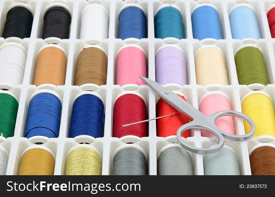 Colorful sewing threads with scissors and needle