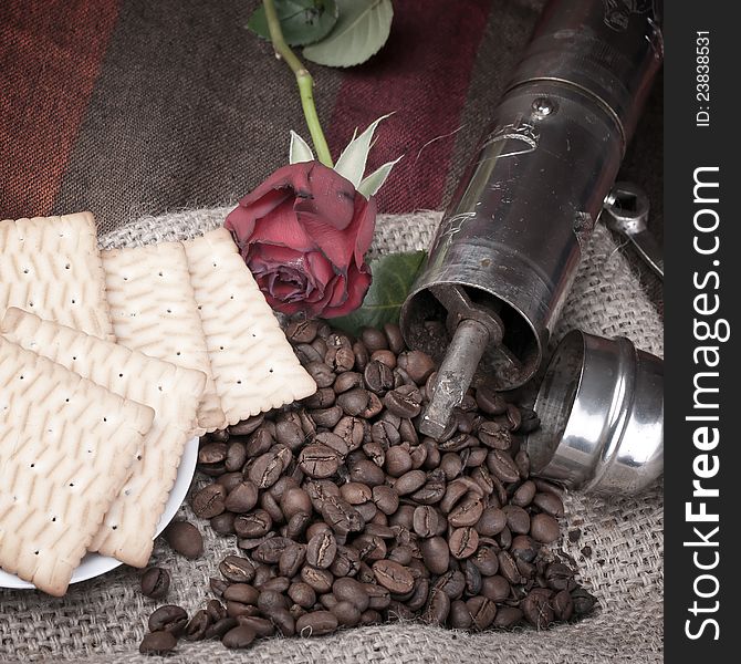 Coffee grinder, coffee beans and roses on the table