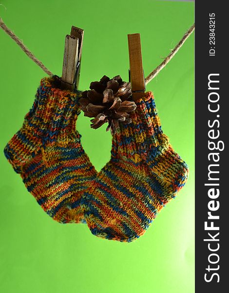 Wool socks for little kids hanging on the washing line also a pine cone. Wool socks for little kids hanging on the washing line also a pine cone