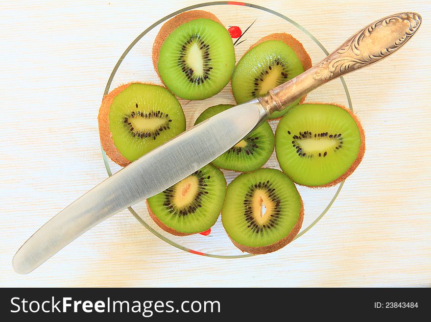 slice of kiwi in TRANSPARENT GLASS vases and knife on the table. slice of kiwi in TRANSPARENT GLASS vases and knife on the table.