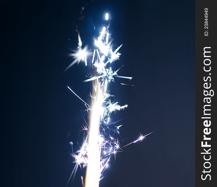 Burning firework on blue background