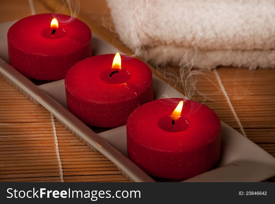 Three scented candles on bamboo mat. Three scented candles on bamboo mat