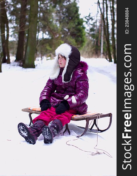 Unhappy kid girl alone in winter forest background