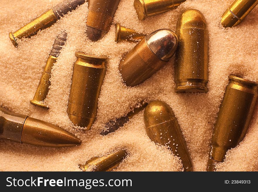 Several different gun and riffle bullets lying in sand. Several different gun and riffle bullets lying in sand