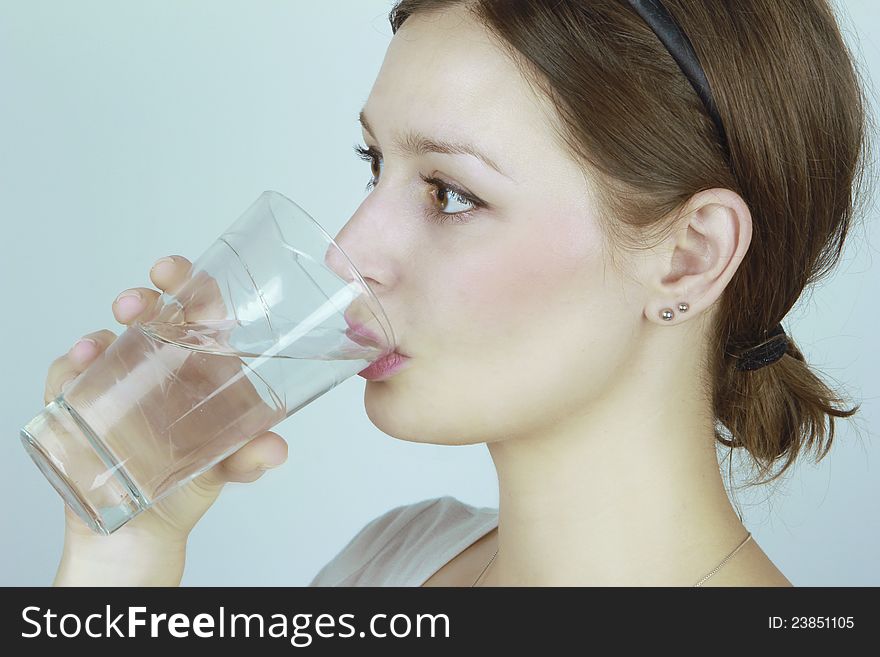 Closeup portrait of a young woman drinking water.