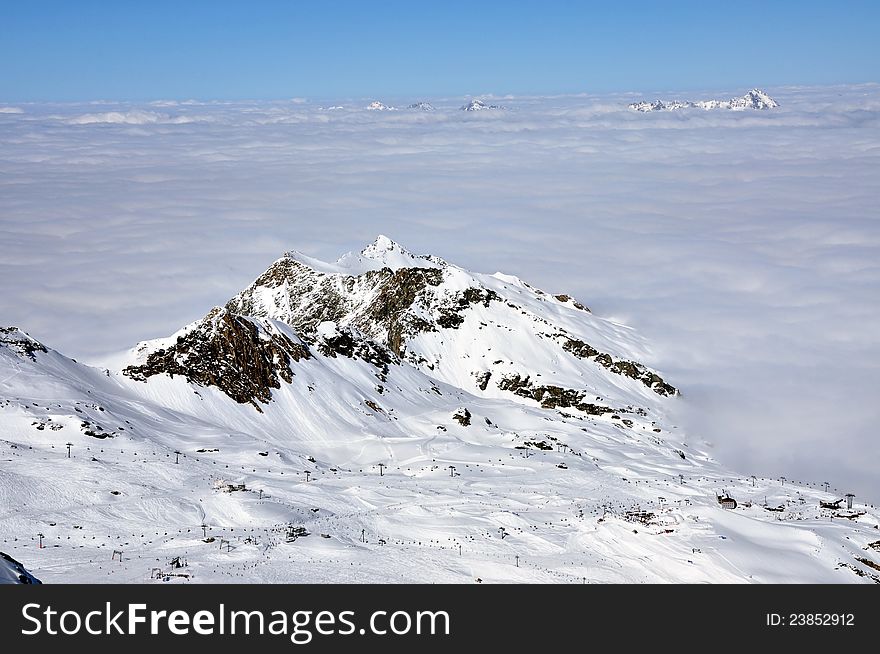 Clouds and fog above, winter landscape in the Alps