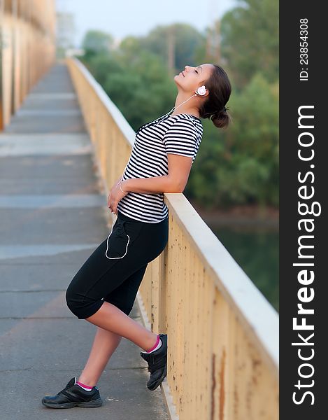 Pretty Teenage Girl Listening Music On The Bridge