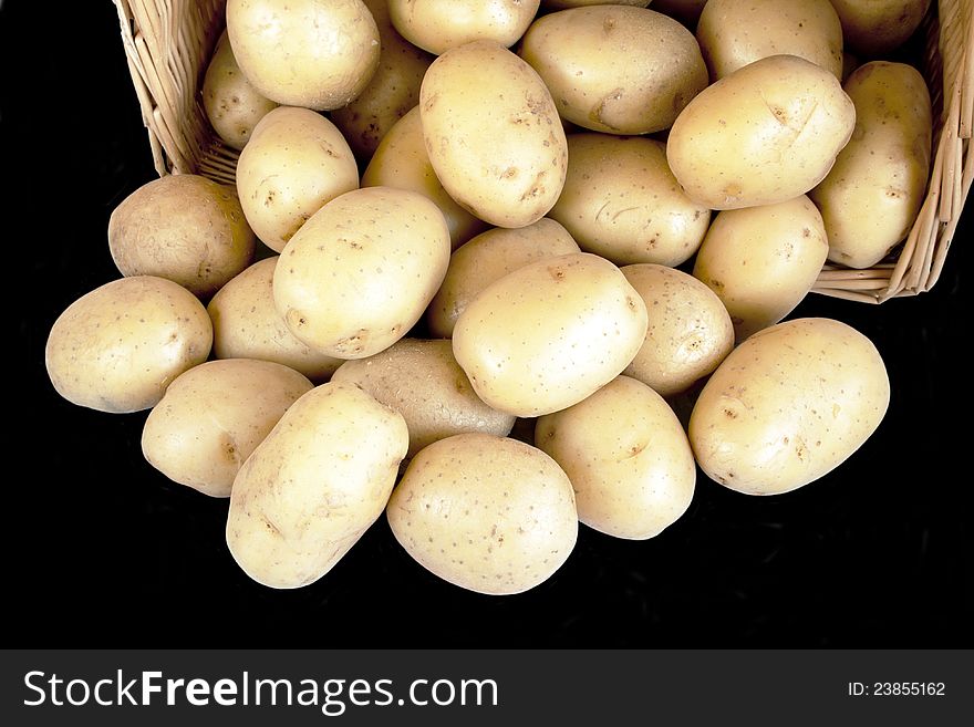 Potatoes in wicker basketl isolated on black background. Potatoes in wicker basketl isolated on black background