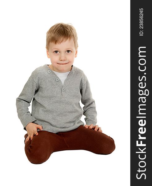 Child is sitting in the studio on a white background