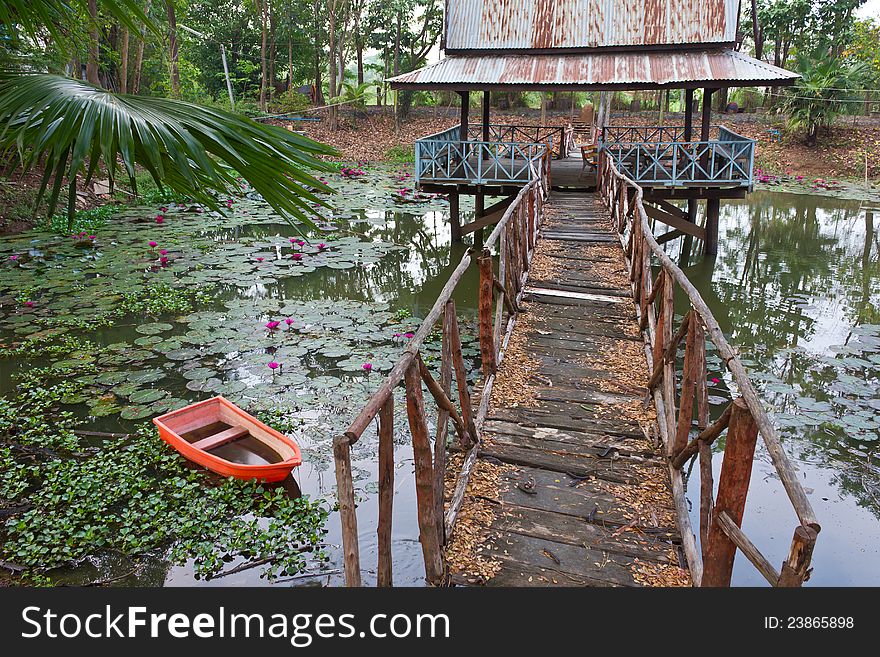 An old wooden bridge that stretches to the hall on the pond. An old wooden bridge that stretches to the hall on the pond.