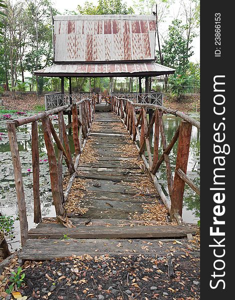 An old wooden bridge that stretches to the hall on the pond. An old wooden bridge that stretches to the hall on the pond.