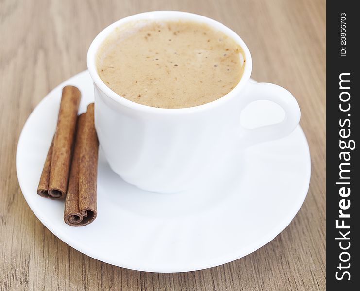 Cup of cappuccino with cinnamon on the table