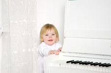Girl Sitting Next To A White Piano Royalty Free Stock Image