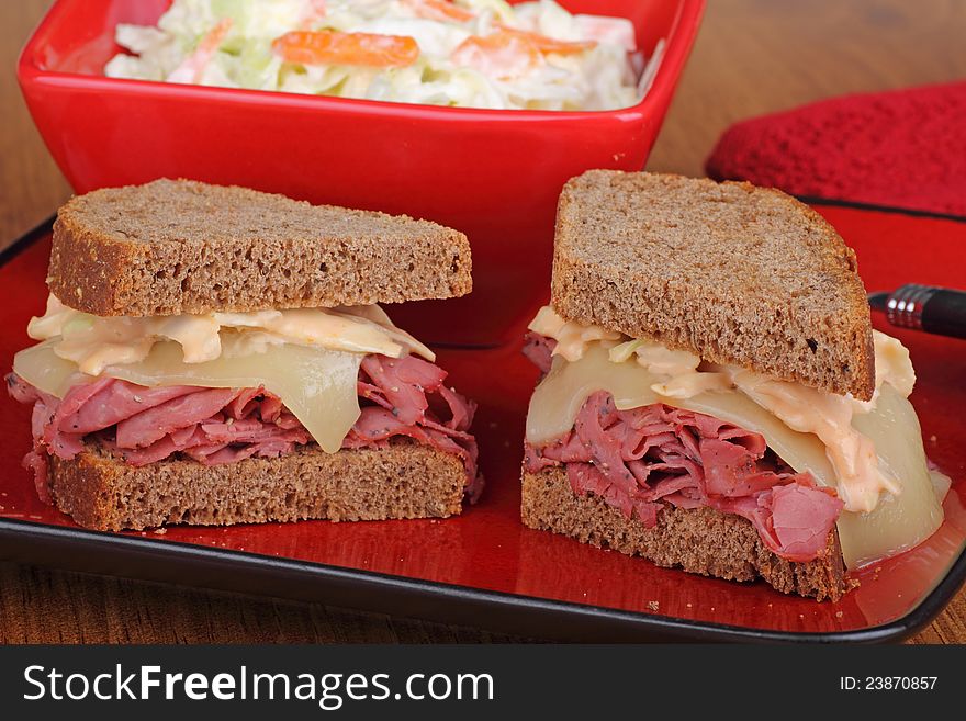 Pastrami and cheese sandwich cut in half on a plate. Pastrami and cheese sandwich cut in half on a plate