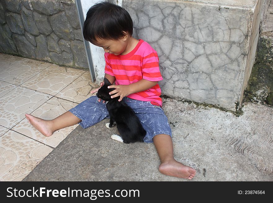 An Indonesian children with a cat. An Indonesian children with a cat.