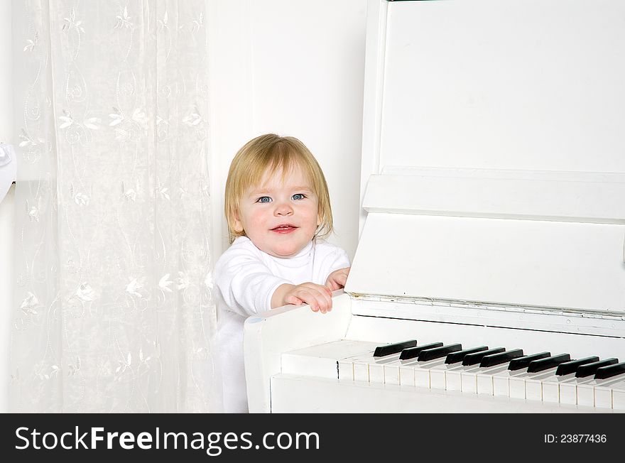 Girl sitting next to a white piano