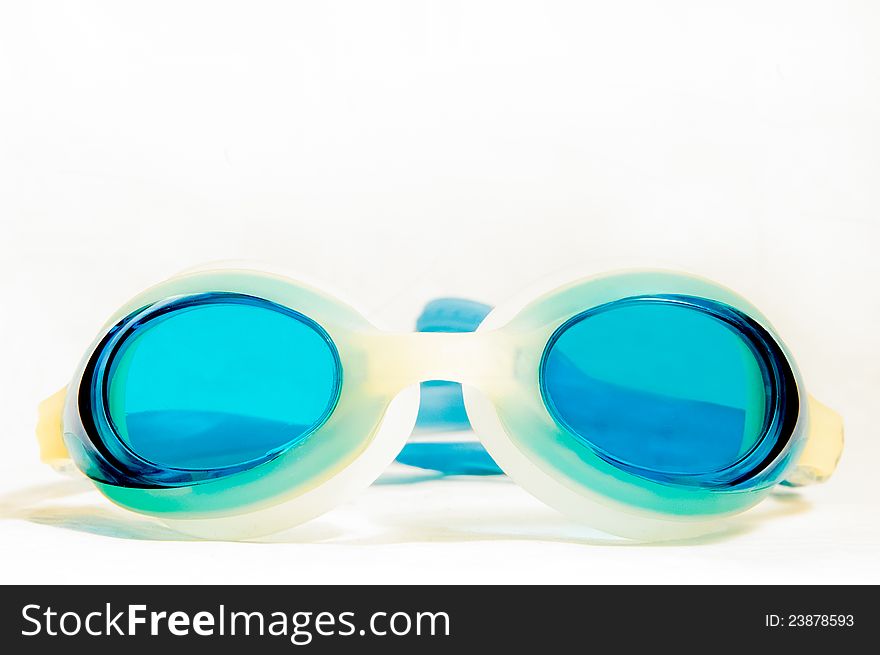 Blue swimming goggles against a white grey background