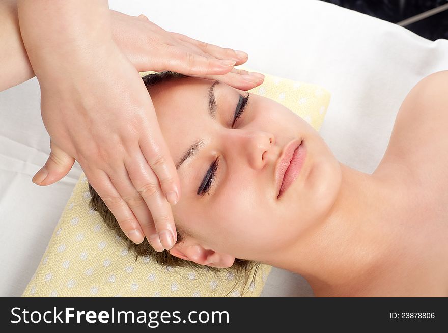Beautiful young woman getting a face massage from professional massager. Beautiful young woman getting a face massage from professional massager.