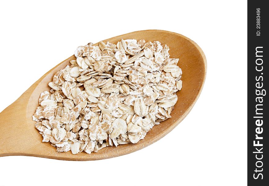 Dry rolled oats seed in wooden spoon over white background. Dry rolled oats seed in wooden spoon over white background