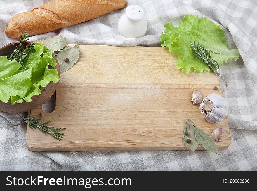 Wood board on the tablecloth with produce around