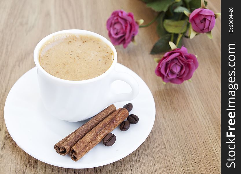 Cup of cappuccino with cinnamon and coffee beans